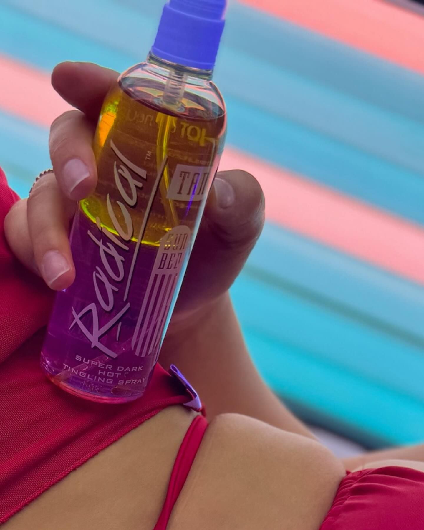 A bottle of Radical held up in a lit sunbed