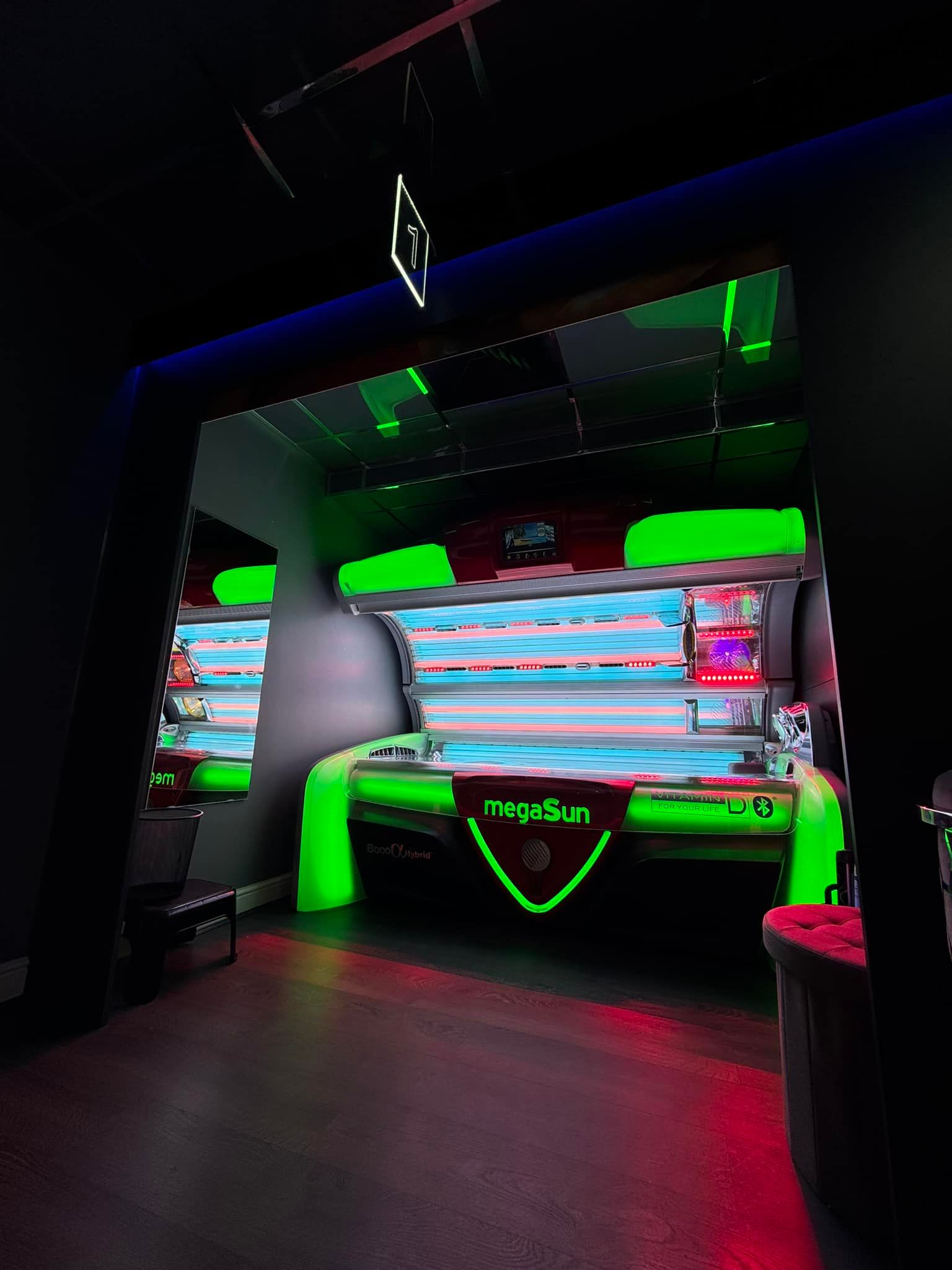 The megaSun 8000 α Hybrid glowing green in its room at Tantastic Tanning